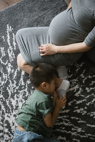 Boy with pregnant mother at home photo