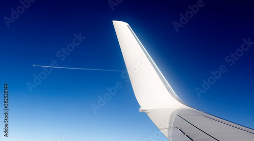 View of jet plane wing with cloud patterns