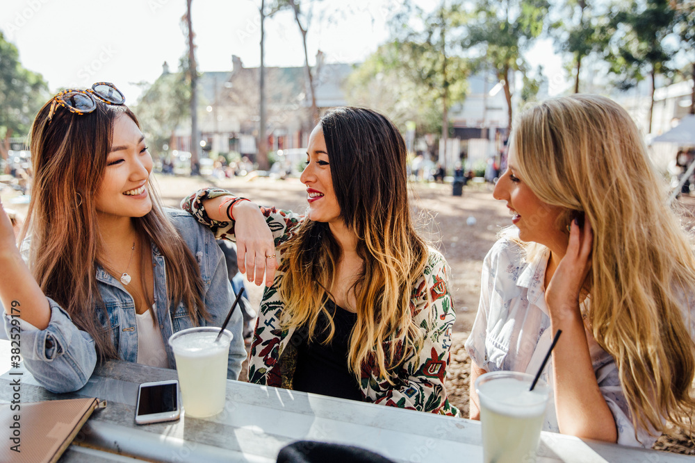 Three Women Enjoying Lemonade at an Outdoor Market Three Women Enjoying Lemonade at an Outdoor Market