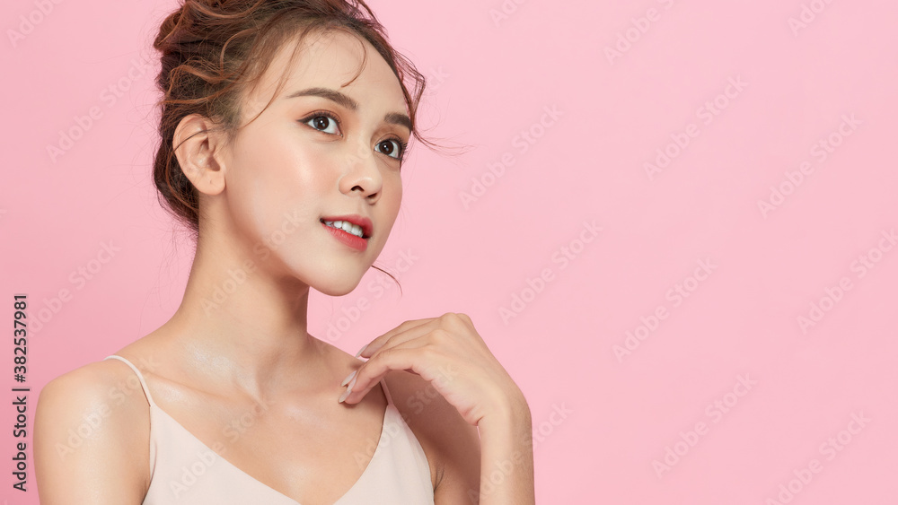 Smiling young cute Asian woman with Korean hairstyle in soft pink background Smiling young cute Asian woman with Korean hairstyle in soft pink background