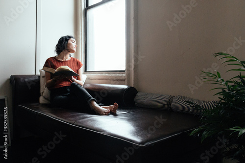 Woman reading a book on a sofa