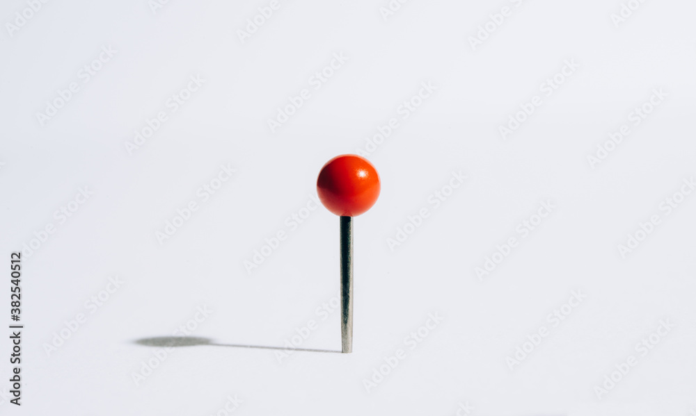 A red push pin casting a shadow. A red push pin casting a shadow.