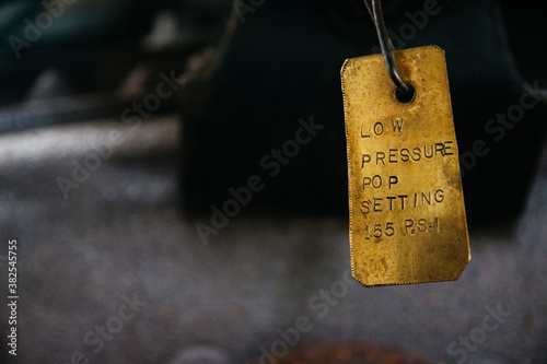 Brass label on a valve indicating low pressure setting