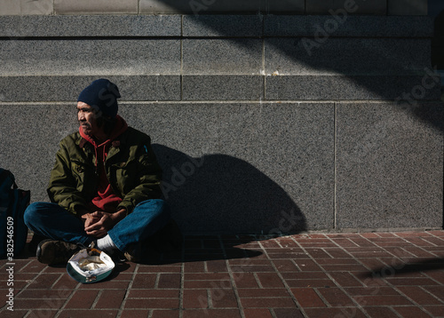 Portrait of older, native homeless man panhandling on the sidewalk