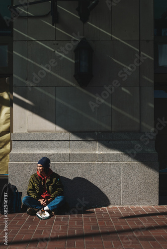 Portrait of older, native homeless man panhandling on the sidewalk photo