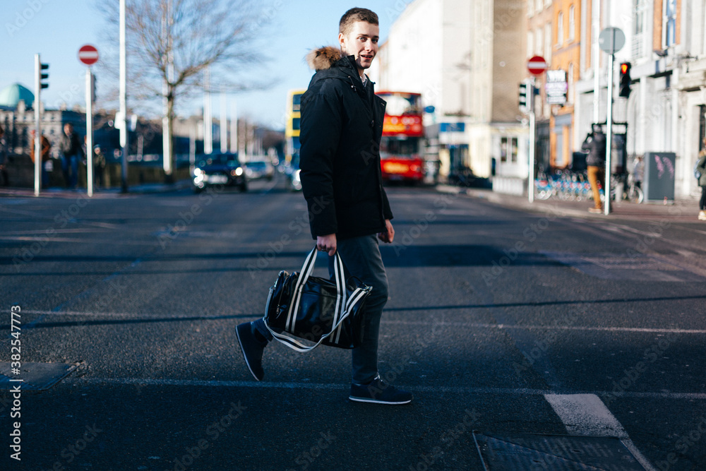 Young Man Crossing the Street in Dublin Ireland Young Man Crossing the Street in Dublin Ireland