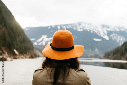 young female looks away from the camera by lake in mountains photo