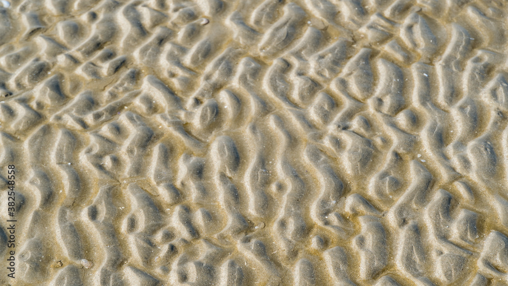 Aerial top view of clear water and patterned sand as the tide comes in at the beach. Aerial top view of clear water and patterned sand as the tide comes in at the beach.