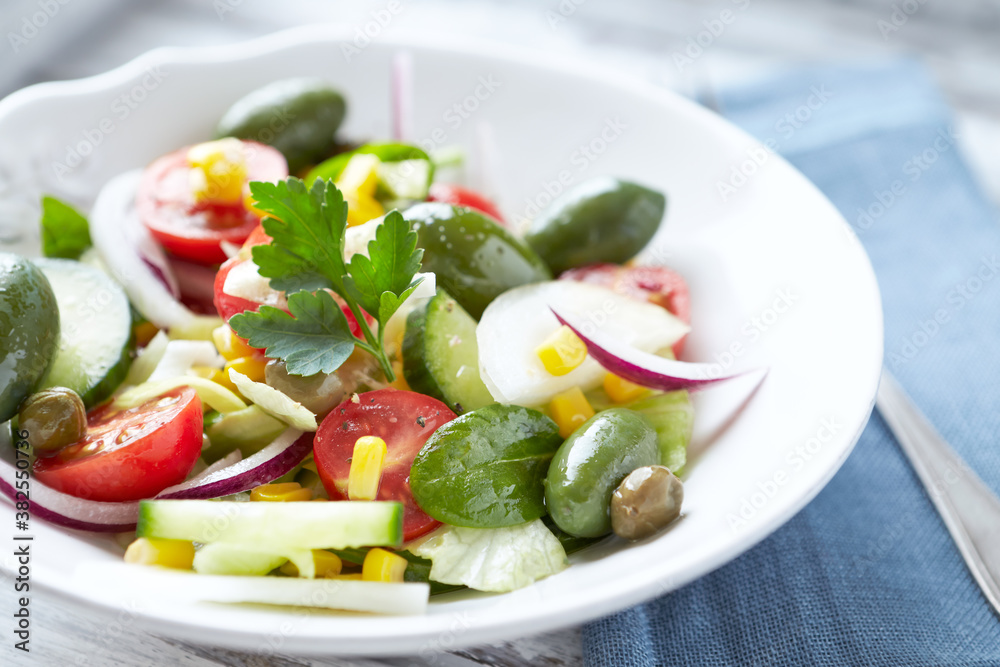 Healthy Salad with Green Olives, Baby Spinach, Cucumber, Cherry Tomatoes and Capers. Bright background. Close up. Healthy Salad with Green Olives, Baby Spinach, Cucumber, Cherry Tomatoes and Capers. Bright background. Close up.