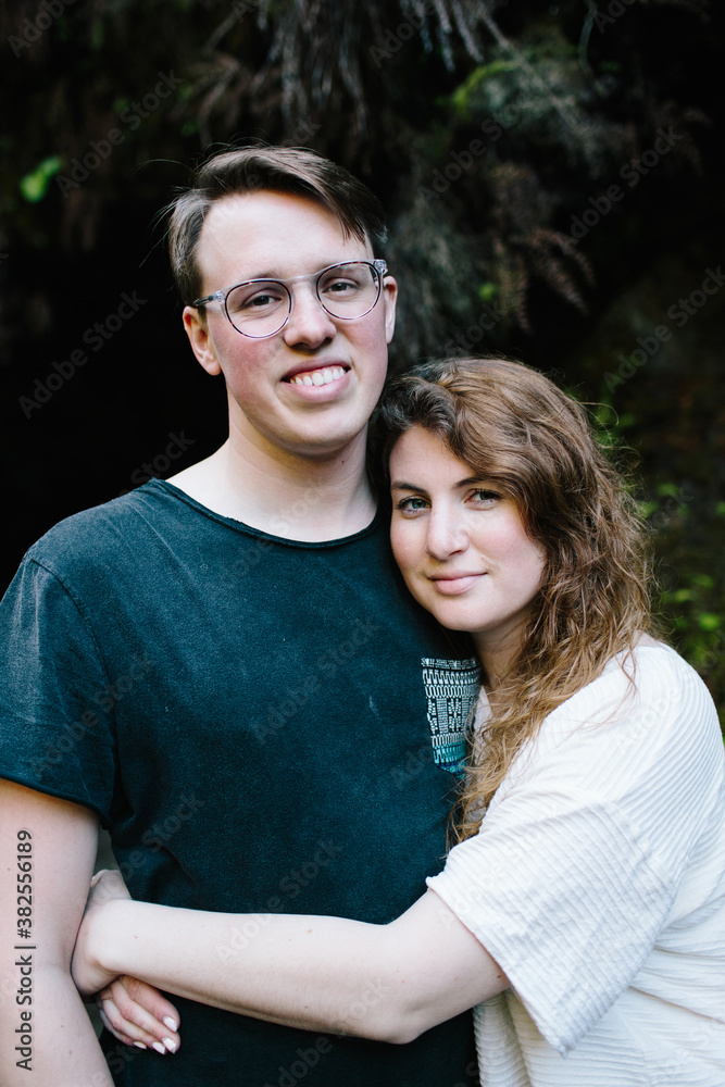 couple embracing and smiling in the woods couple embracing and smiling in the woods