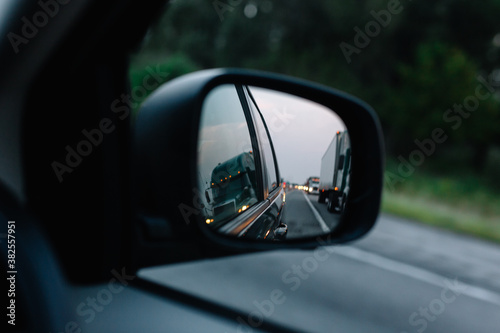 rear view mirror of trucks on highway photo