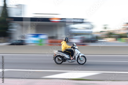 Barcelona, Spain; May 5, 2017: Panning of one fast scooter in the city.  People S