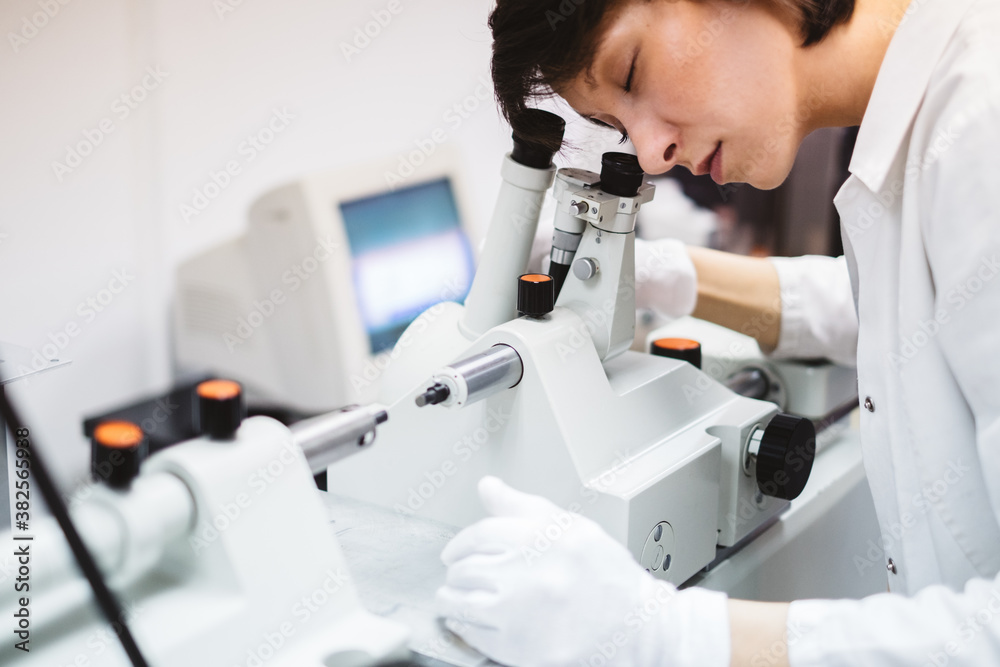Female Chemist Looking Through the Microscope Female Chemist Looking Through the Microscope