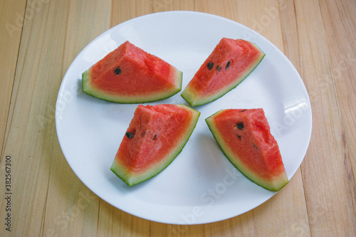 closeup slice pieces of refreshing watermelon on a wooden background