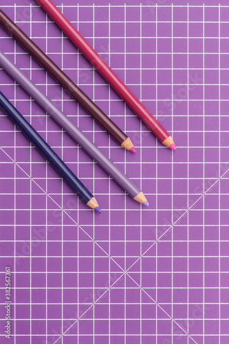 purple coloured pencils on a purple grid background photo