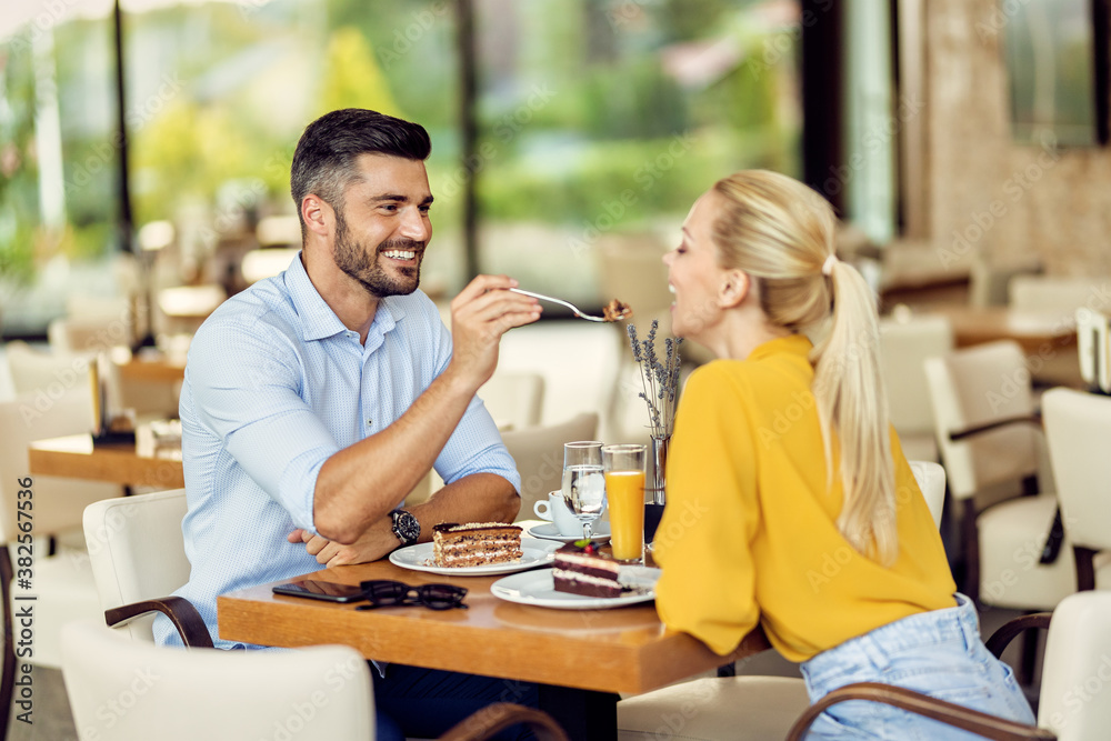 Happy couple in love sharing dessert in a cafe. Happy couple in love sharing dessert in a cafe.