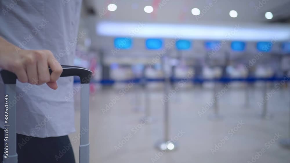 Close up of Young female hand grip on suitcase handle walking with