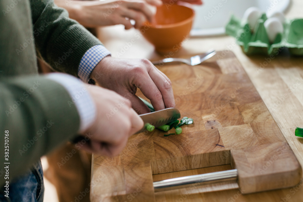 Mature man cutting spring onion Mature man cutting spring onion
