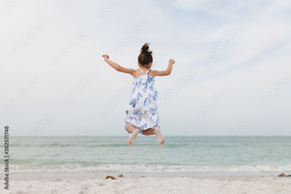 Young girl jumping high in the sand Young girl jumping high in the sand