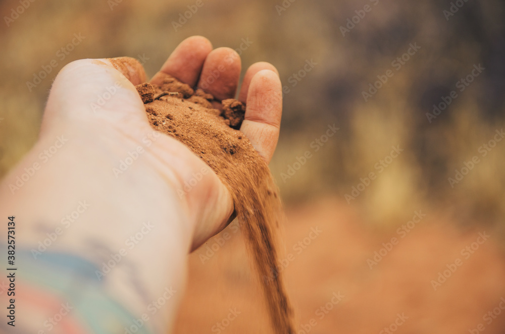 Red sand slipping through a hand Red sand slipping through a hand