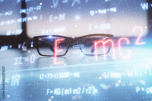 Formulas drawing with glasses on the table background. Concept of science. Double exposure. © peshkova