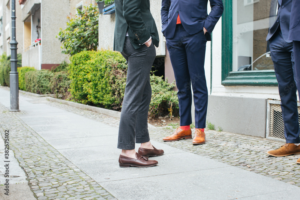 Men's Fashion - Legs of Three Men in Suit Standing on City Sidewalk Men's Fashion - Legs of Three Men in Suit Standing on City Sidewalk