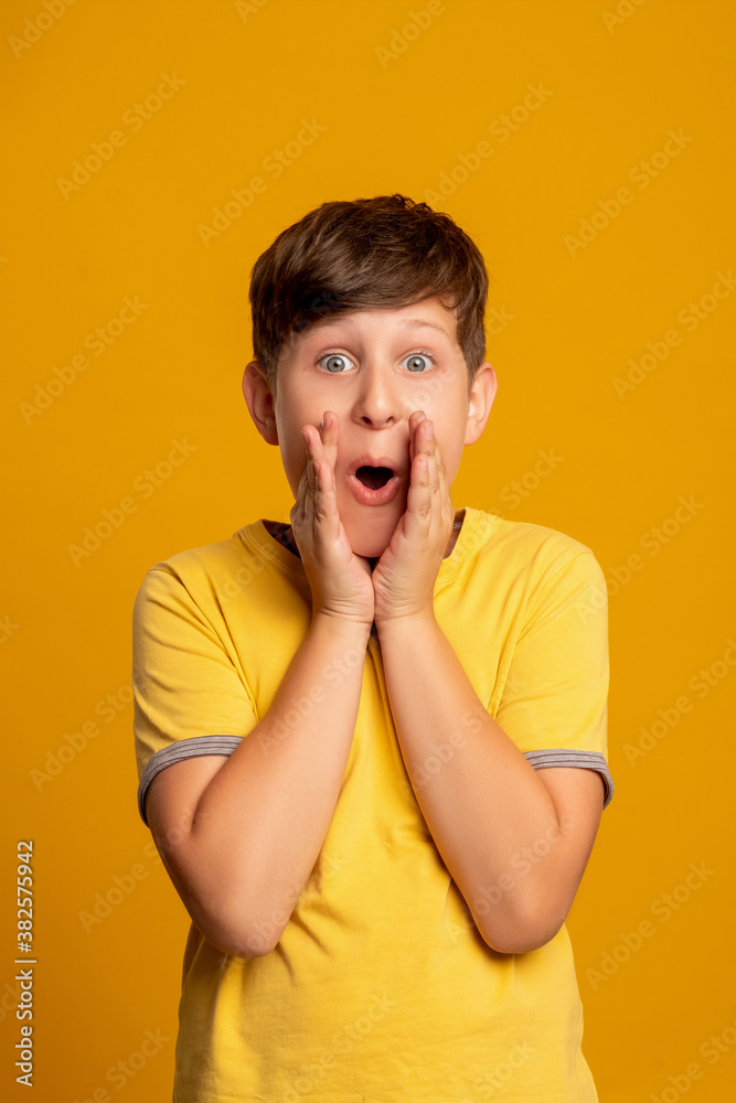 Excited child. Unbelievable success. Victory celebration. Dream opportunity. Portrait of surprised amazed young boy with open mouth supporting isolated on orange background. Excited child. Unbelievable success. Victory celebration. Dream opportunity. Portrait of surprised amazed young boy with open mouth supporting isolated on orange background.
