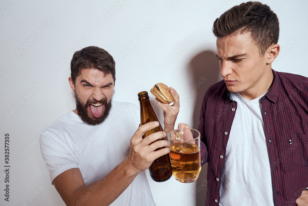 Two friends drink beer leisure fun alcohol friendship lifestyle light background Two friends drink beer leisure fun alcohol friendship lifestyle light background