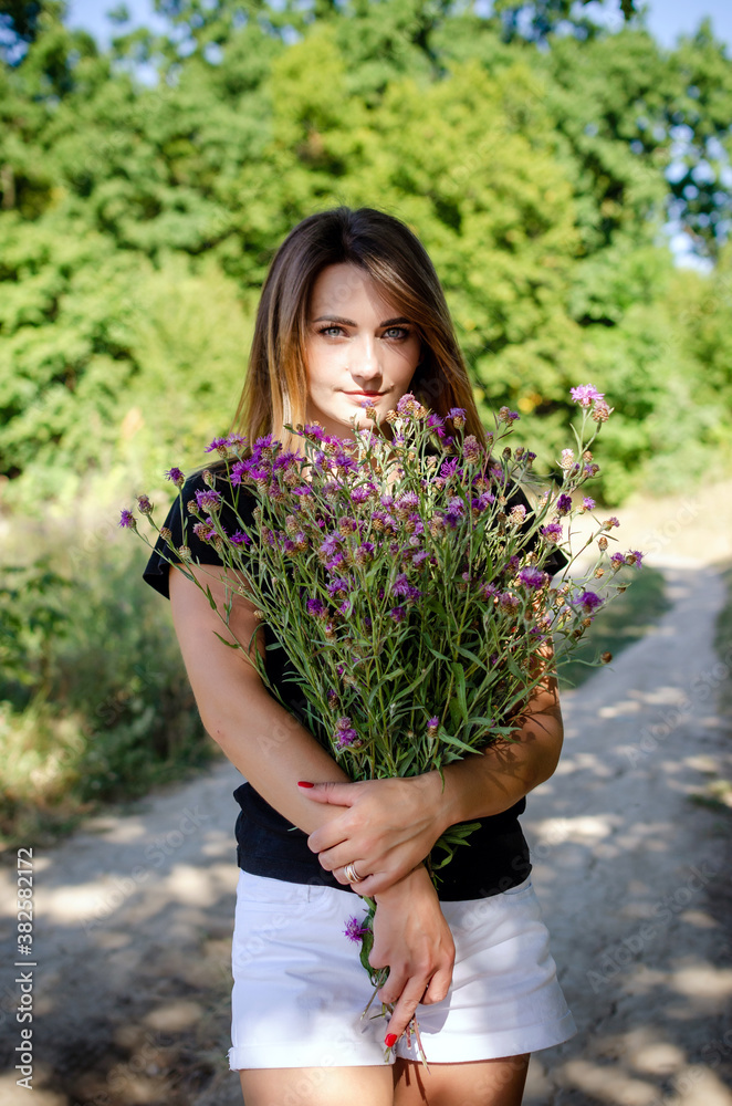 Young cute woman with flowers in hands Young cute woman with flowers in hands