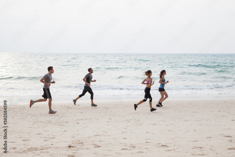 Group of friends running together at the beach Group of friends running together at the beach