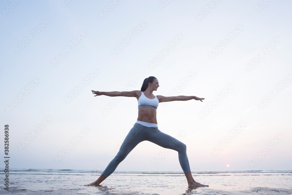 Woman practising yoga at sunset. Woman practising yoga at sunset.