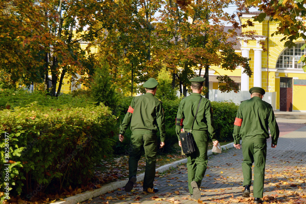 Obraz premium A three-man military patrol in the autumn city park.