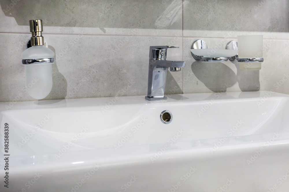 Fototapeta premium Ceramic Water tap sink with faucet with soap and shampoo dispensers in expensive loft bathroom or kitchen