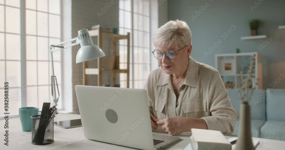 Senior lady using her laptop computer for video chatting. Mature woman talking with employees or students during video conference 4k footage Senior lady using her laptop computer for video chatting. Mature woman talking with employees or students during video conference 4k footage