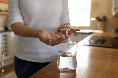 Mid section of woman sanitizing her hands at home photo