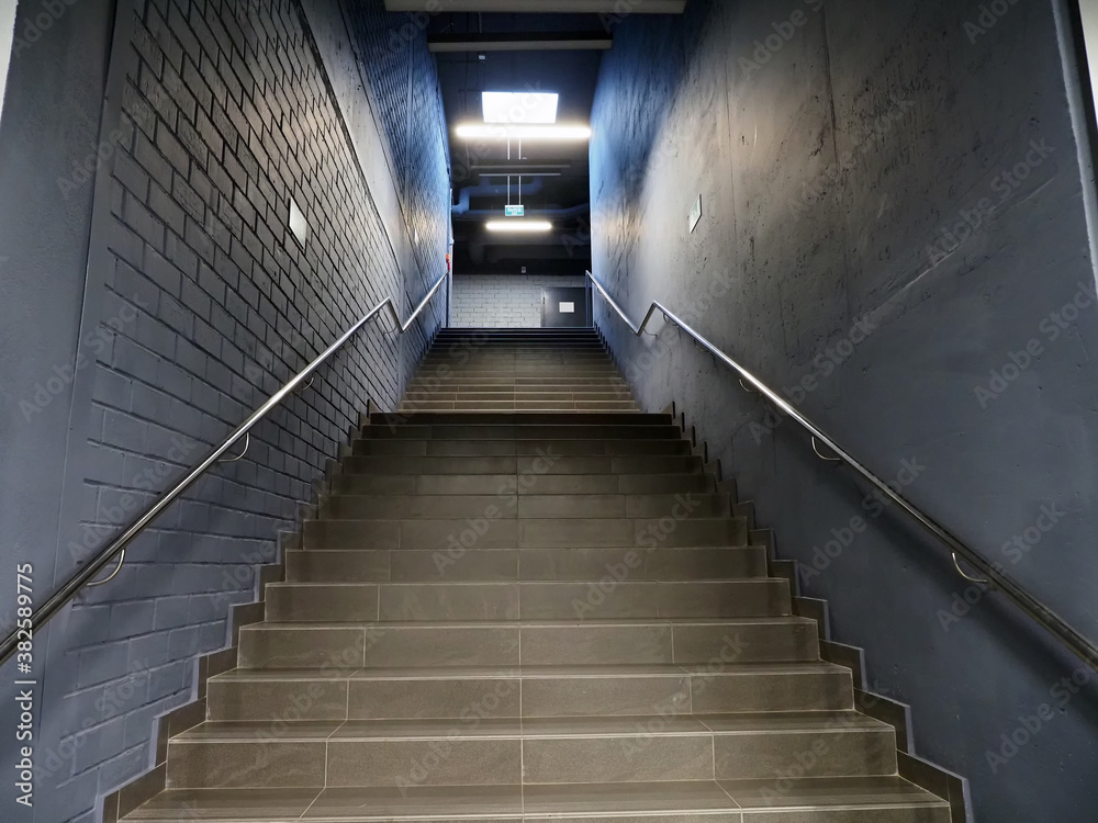 Fototapeta premium Gloomy narrow dark staircase up to the sign 