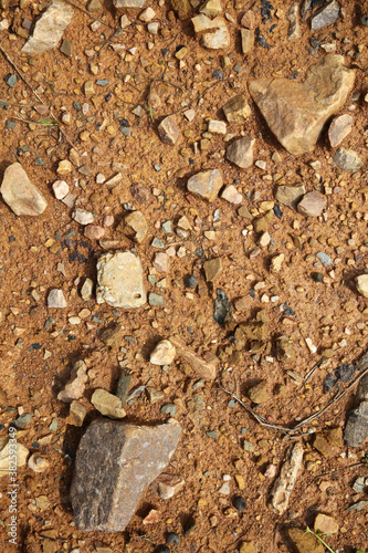 Moist yellow soil with lots of small stones  detailed texture