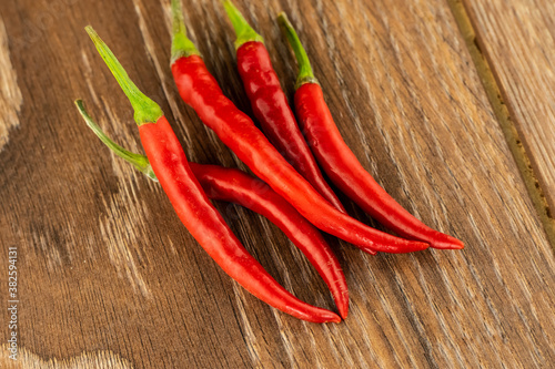 hot ripe chili peppers group of vegetables spices asia lies on a brown wood