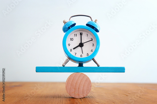 Photography Concept of finding the right balance. vintage clock on seesaw