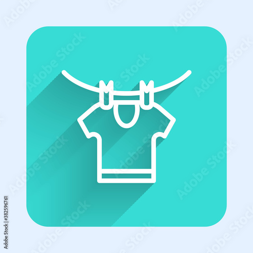 White line Drying clothes icon isolated with long shadow. Clean shirt. Wash clothes on a rope with clothespins. Clothing care and tidiness. Green square button. Vector.