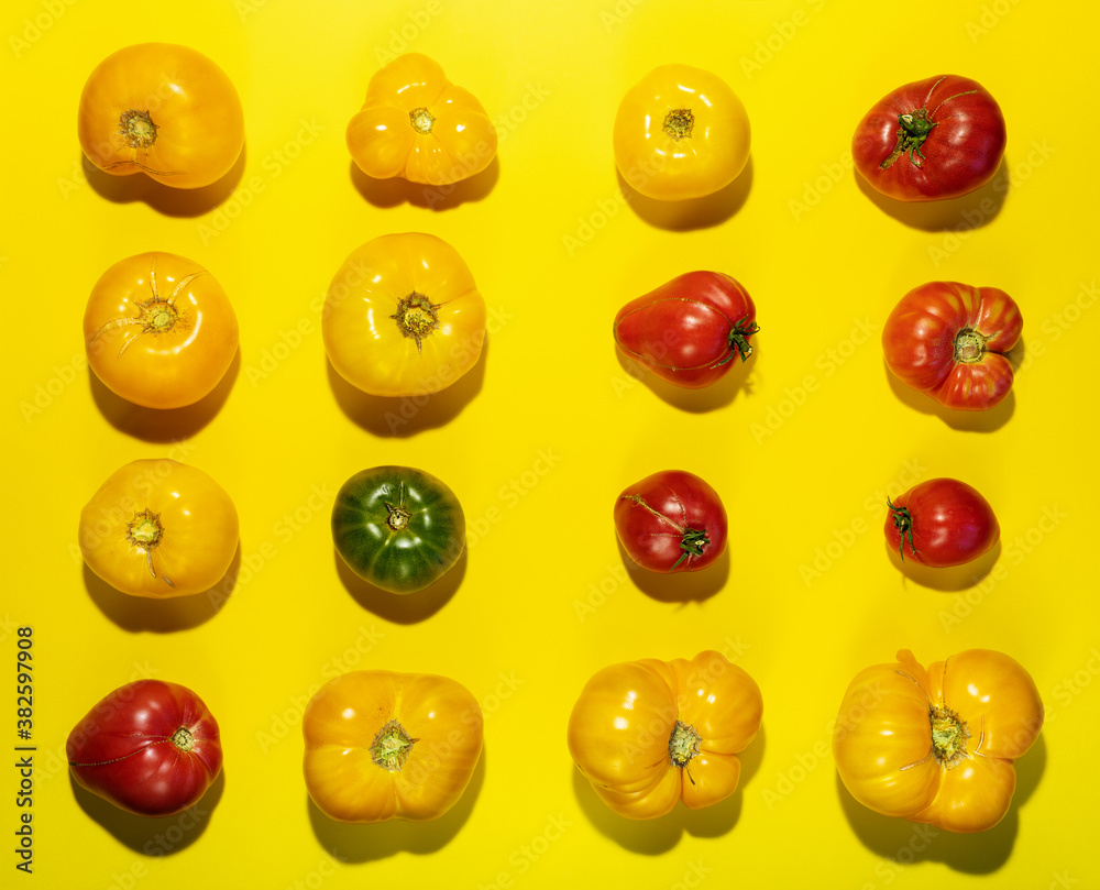 Rhythm pattern of different color farm tomatoes on bright yellow background. Top view, flat lay. Rhythm pattern of different color farm tomatoes on bright yellow background. Top view, flat lay.