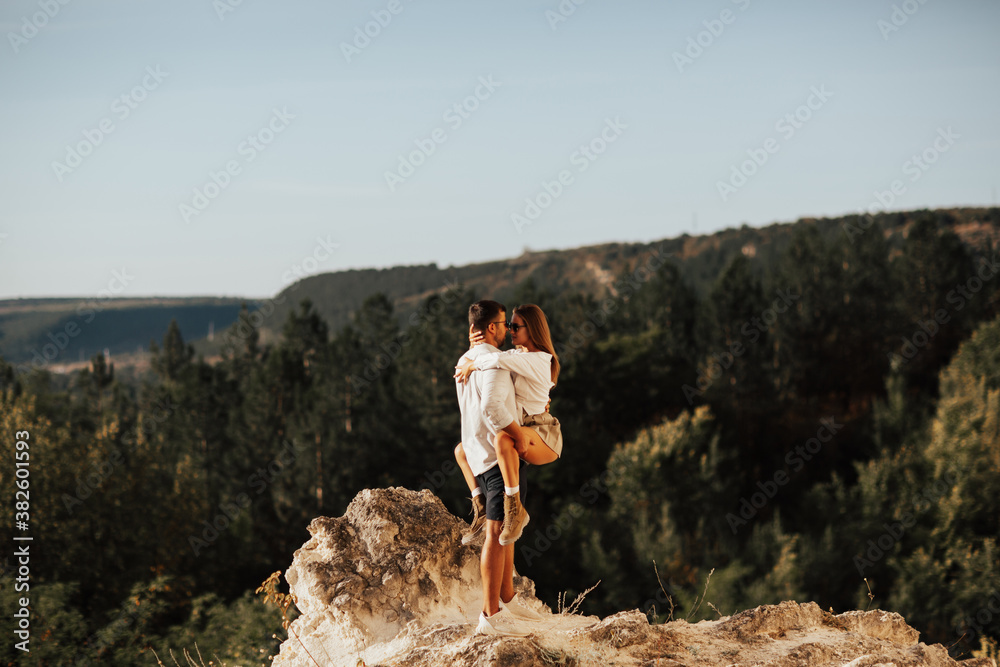 Sexy couple in the mountain. They standing and hugging on the stony place. A couple in love has wonderful moments of happiness and joy. Love and tenderness.
