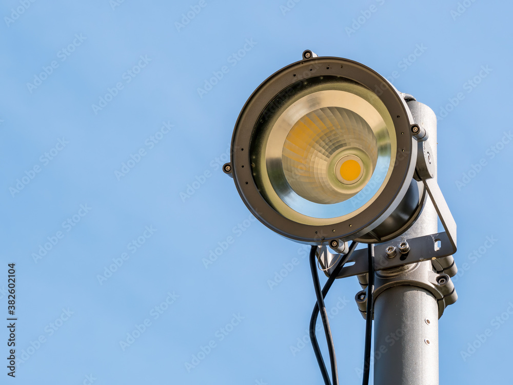Spot light or bulb light against clear blue sky. Led lamp with directional light Spot light or bulb light against clear blue sky. Led lamp with directional light