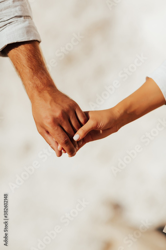 Obraz na płótnie Couple on summer sunny day. Woman and man holding hands. Close up of a couple holding hands. w salonie