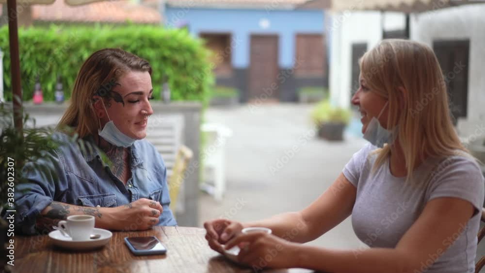 Young friends taking a coffee together and chatting during coronavirus outbreak - Social distance concept Young friends taking a coffee together and chatting during coronavirus outbreak - Social distance concept