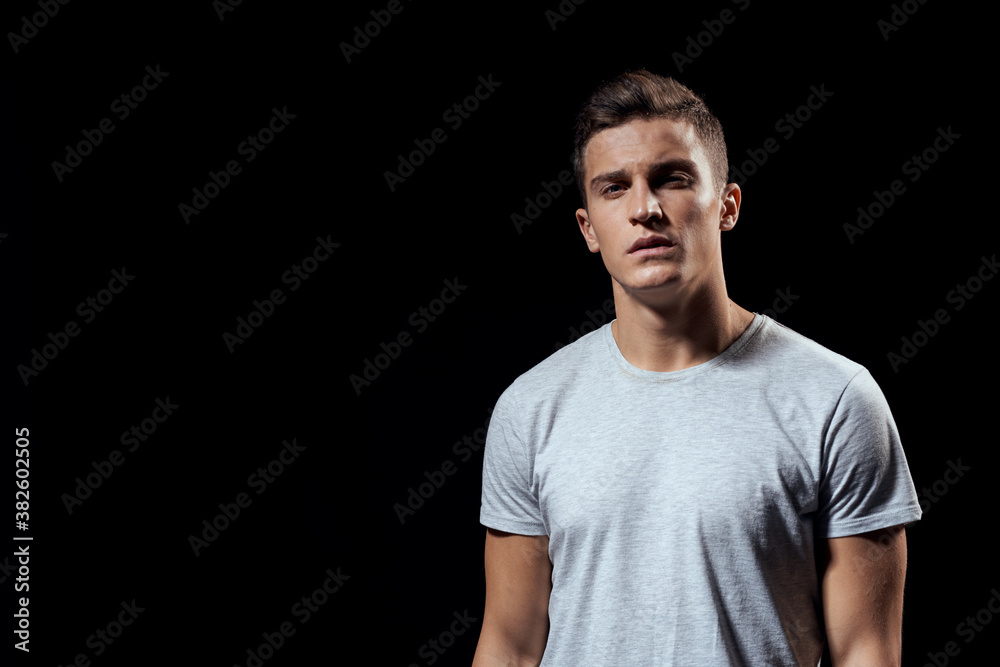 handsome man in white t-shirt on black background inflated arm muscles sport model cropped view Copy Space handsome man in white t-shirt on black background inflated arm muscles sport model cropped view Copy Space
