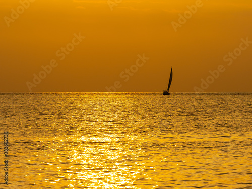 ヨットと夕暮れの金色に輝く海 © 正人 竹内