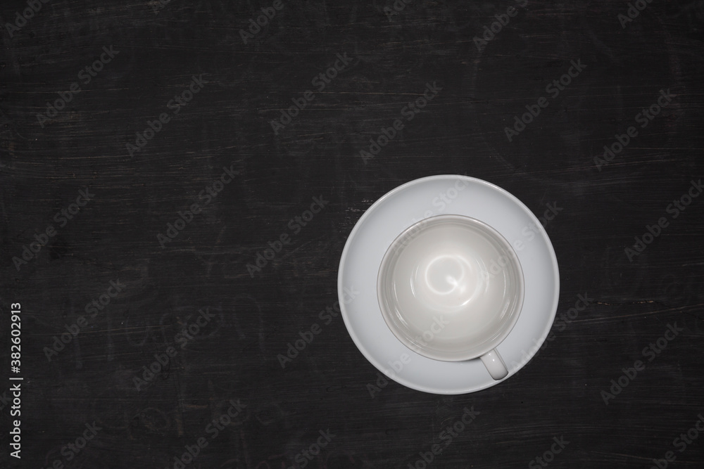Top view of an empty coffee cup on black wooden table