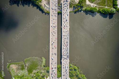 Cars driving through the bridge between two islands. Top down view from drone.