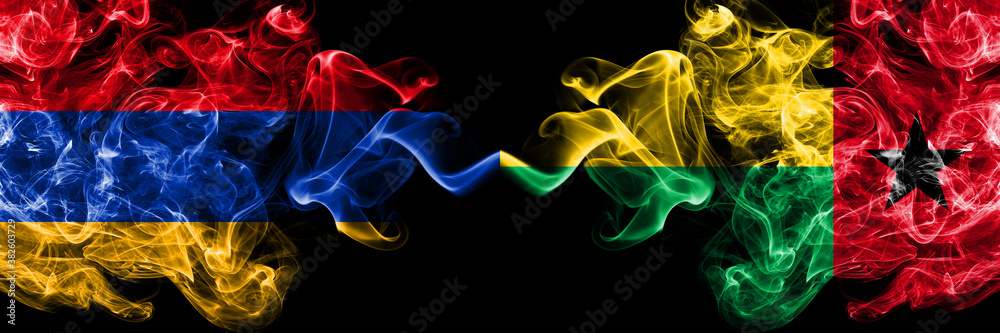 Obraz premium Armenia vs Guinea Bissau smoky mystic flags placed side by side. Thick colored silky abstract smoke flags